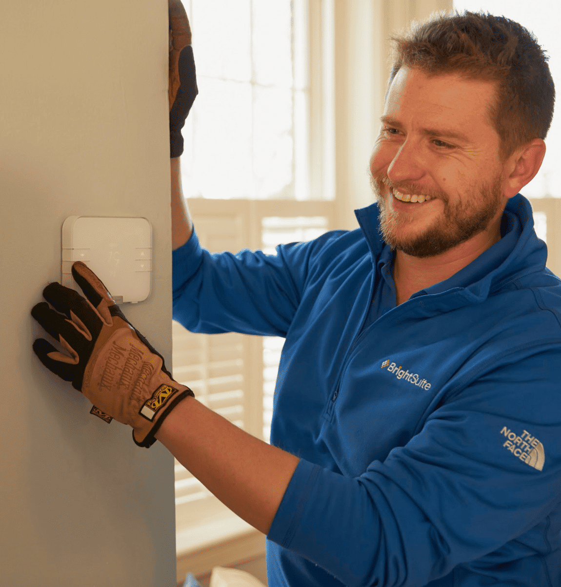A BrightSuite employee installs a smart home security device in a home.