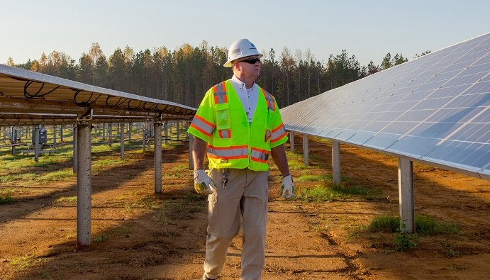 worker looking at solar panels