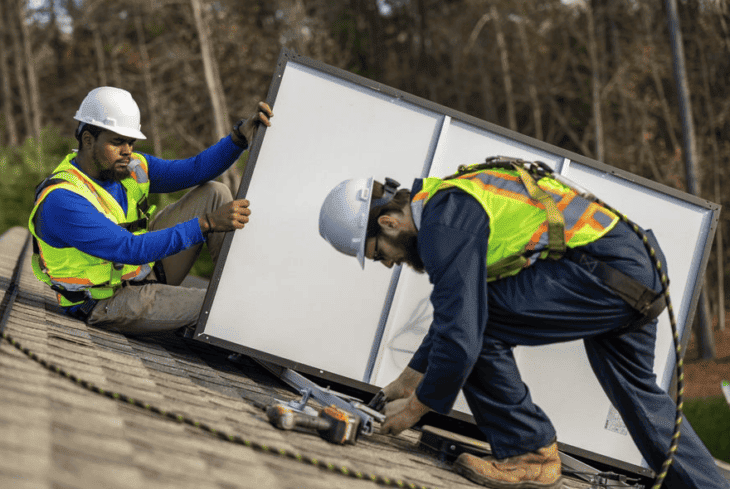 installers putting solar panels on a residential roof