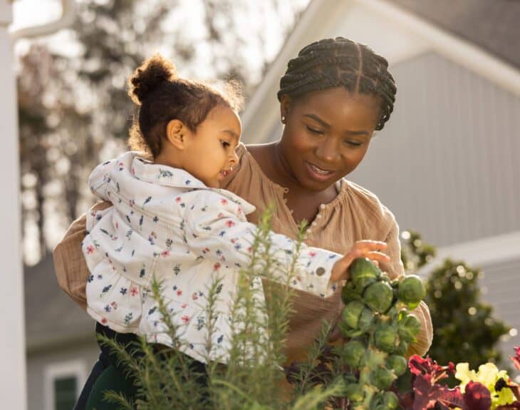 woman and child outside their home on a sunny day