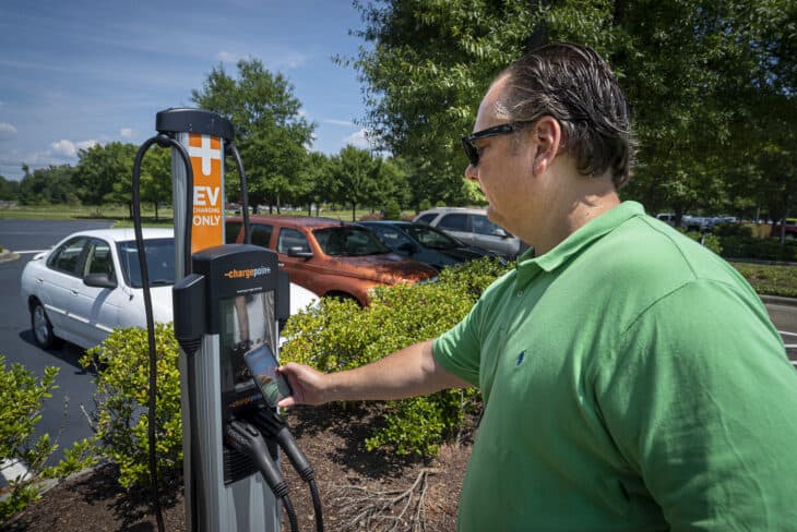 Man preparing to use a commercial EV charging station