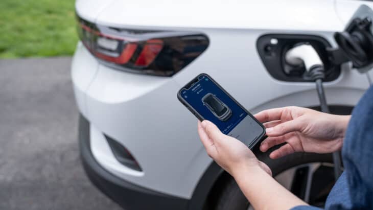 EV driver checking the charging status of their SUV from their mobile phone