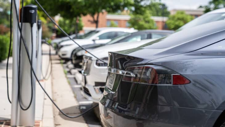 Row of electric cars charging in outdoor parking lot