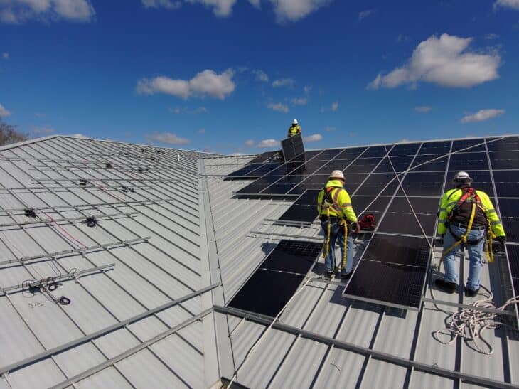 Installers adding solar panels to a roof