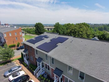 Rooftop solar panels on two townhouses in an urban setting