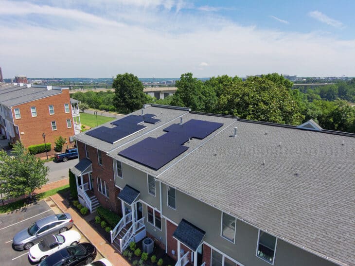 Rooftop solar panels on two townhouses in an urban setting