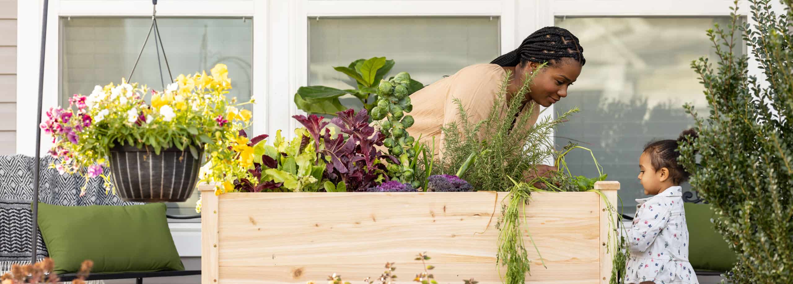 mom and daughter gardening outside their home